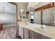 Bathroom with dual sinks, wood accent wall, and tile floors leading to the connecting bedroom at 6689 Sparks Ave, Las Vegas, NV 89142