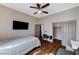 Cozy bedroom featuring hardwood floors, a ceiling fan, and a wall-mounted TV at 6689 Sparks Ave, Las Vegas, NV 89142