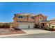 Inviting two-story home with a three-car garage, desert landscaping, and a covered front porch area at 6689 Sparks Ave, Las Vegas, NV 89142
