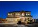 Charming two-story home with a three car garage, covered porch, and well-maintained front yard at dusk at 6689 Sparks Ave, Las Vegas, NV 89142