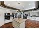 Open concept kitchen with granite island, stainless steel appliances, and hardwood floors at 6689 Sparks Ave, Las Vegas, NV 89142