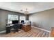 Home office with corner desk, wood-look flooring, windows, and an elegant light fixture at 6689 Sparks Ave, Las Vegas, NV 89142