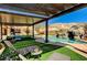 Stunning backyard with a sparkling pool, rock waterfall, artificial turf, covered patio, and comfortable lounge seating at 6689 Sparks Ave, Las Vegas, NV 89142