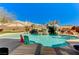 Relaxing backyard pool featuring a rock waterfall, lush landscaping, and clear blue water for ultimate enjoyment at 6689 Sparks Ave, Las Vegas, NV 89142
