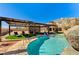 Inviting backyard pool and lounge area with a large pergola, synthetic grass and mature landscaping at 6689 Sparks Ave, Las Vegas, NV 89142