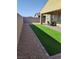 Low-maintenance backyard featuring gravel, artificial turf, and a covered patio at 697 Sunray Park St, Henderson, NV 89011