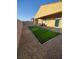 Backyard featuring a covered patio, pavers, a narrow strip of artificial turf, and a gravel border at 697 Sunray Park St, Henderson, NV 89011