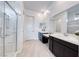 A bright bathroom featuring double vanities, a glass-enclosed shower, and modern fixtures at 697 Sunray Park St, Henderson, NV 89011