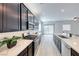 Open concept kitchen features stainless steel appliances, quartz countertops and gray vinyl floors at 697 Sunray Park St, Henderson, NV 89011