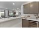 Modern kitchen featuring a breakfast bar, gray cabinets, and a beverage refrigerator at 7153 Grace Estate Ave, Las Vegas, NV 89113