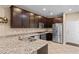 Beautiful kitchen featuring dark cabinets, granite countertops, and stainless steel appliances at 7253 Sterling Rock Ave, Las Vegas, NV 89178