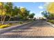 Tree-lined neighborhood entrance with lush landscaping and decorative pavers, creating a welcoming arrival at 7253 Sterling Rock Ave, Las Vegas, NV 89178