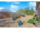 Landscaped backyard with desert plants, rock ground cover, and a brick wall for privacy, offering a serene outdoor space at 7633 Lily Trotter St, North Las Vegas, NV 89084