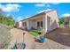 Private backyard featuring gravel landscaping, a covered patio with seating, and drought-tolerant plants for easy maintenance at 7633 Lily Trotter St, North Las Vegas, NV 89084