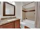 Bathroom featuring granite vanity, large mirror, toilet, and bathtub with shower at 7633 Lily Trotter St, North Las Vegas, NV 89084