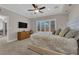 Spacious bedroom with cozy carpet, TV, dresser, and natural light from the shuttered windows at 7633 Lily Trotter St, North Las Vegas, NV 89084