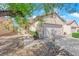Charming single-story home featuring a two-car garage, neutral stucco exterior, and desert landscaping with a sidewalk at 7633 Lily Trotter St, North Las Vegas, NV 89084