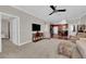 Comfortable living room with plush carpet flooring, neutral paint, crown molding, and views into the kitchen at 7633 Lily Trotter St, North Las Vegas, NV 89084
