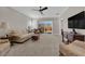 Inviting living room with neutral tones, a ceiling fan, carpeted flooring and a sliding glass door at 7633 Lily Trotter St, North Las Vegas, NV 89084