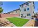 Expansive backyard with artificial turf, a patio area, and a view of the home's exterior at 7665 Sandhaven St, Las Vegas, NV 89139