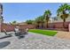 Backyard features a landscaped area, stone pavers, and a seating area with views of palm trees at 7665 Sandhaven St, Las Vegas, NV 89139