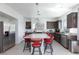 Modern kitchen featuring granite countertops, dark wood cabinets, stainless steel appliances, and a spacious island at 7665 Sandhaven St, Las Vegas, NV 89139