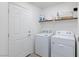 Convenient laundry room features a washer, dryer, and storage shelves for organization at 7665 Sandhaven St, Las Vegas, NV 89139