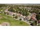 Beautiful aerial view of houses on a lush golf course with mature trees and community in the background at 7999 Pinnacle Peak Ave, Las Vegas, NV 89113