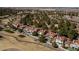 Aerial view featuring houses with red roofs nestled among trees and adjacent to a golf course and pond at 7999 Pinnacle Peak Ave, Las Vegas, NV 89113