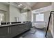 Modern bathroom with dual sinks, a large soaking tub, and sleek gray cabinetry at 7999 Pinnacle Peak Ave, Las Vegas, NV 89113