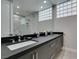 Modern bathroom features a double vanity with sleek gray cabinetry and a large mirror at 7999 Pinnacle Peak Ave, Las Vegas, NV 89113