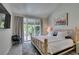 Cozy bedroom features a natural wood bed frame, neutral decor, access to the backyard, and natural light at 7999 Pinnacle Peak Ave, Las Vegas, NV 89113