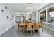 Open concept dining area features tile flooring, modern lighting and a wooden dining table next to an open kitchen at 7999 Pinnacle Peak Ave, Las Vegas, NV 89113