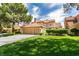 Beautiful two-story home with a terracotta roof, lush lawn, and mature trees at 7999 Pinnacle Peak Ave, Las Vegas, NV 89113