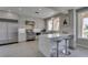 Bright kitchen featuring white cabinetry, stainless appliances, a waterfall island with seating and neutral color palette at 7999 Pinnacle Peak Ave, Las Vegas, NV 89113