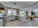 This kitchen features a view into the living room and stainless appliances, white cabinets and island at 7999 Pinnacle Peak Ave, Las Vegas, NV 89113