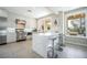 Modern kitchen features stainless steel appliances, white cabinetry, a marble countertop island, and tile flooring at 7999 Pinnacle Peak Ave, Las Vegas, NV 89113