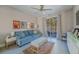 Comfortable living room with blue sofa, ceiling fan, and sliding glass door leading to outdoor space at 7999 Pinnacle Peak Ave, Las Vegas, NV 89113