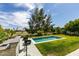 Entertain in the backyard featuring a pristine pool, lush lawn, and an outdoor bar area with barstool seating at 7999 Pinnacle Peak Ave, Las Vegas, NV 89113