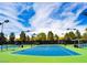 Bright blue community tennis court surrounded by lights and greenery, perfect for daytime or evening play at 7999 Pinnacle Peak Ave, Las Vegas, NV 89113