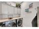 Efficient laundry room with front-loading washer and dryer, upper cabinets and folding countertop at 8144 Skye Dragon St, Las Vegas, NV 89166