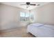 Cozy bedroom with a ceiling fan, carpeted floor, and a window bringing in natural light at 9489 Liquid Loco St, Las Vegas, NV 89178