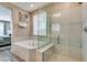 Bathroom featuring soaking tub and glass enclosed shower, with view to primary bedroom at 9519 Chandler Springs Ave, Las Vegas, NV 89148