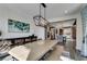 Dining area with adjacent kitchen, featuring a long table and a decorative modern chandelier at 9519 Chandler Springs Ave, Las Vegas, NV 89148