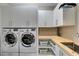 Efficient laundry room with modern washer, dryer, and ample storage cabinets at 9519 Chandler Springs Ave, Las Vegas, NV 89148