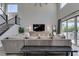 Bright living room with staircase, large TV, and sliding door access to outdoor living space at 9519 Chandler Springs Ave, Las Vegas, NV 89148