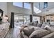 Stylish living room with contemporary furniture, large windows, and seamless flow to kitchen at 9519 Chandler Springs Ave, Las Vegas, NV 89148