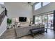 Living room with staircase, large TV, and sliding door access to outdoor living space at 9519 Chandler Springs Ave, Las Vegas, NV 89148