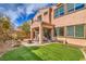 Manicured backyard with a covered patio, artificial turf, and appealing landscaping at 9655 Shadow Cliff Ave, Las Vegas, NV 89166