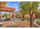 Beautiful backyard with a covered patio, dining set, and landscaped features at 9655 Shadow Cliff Ave, Las Vegas, NV 89166